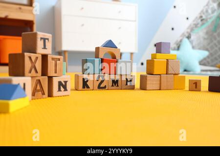 Cubi di legno sul tappeto nella stanza dei bambini, primo piano Foto Stock