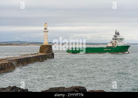 Aberdeen, Scozia, Regno Unito - 17 settembre 2023: Una barca lascia il porto e passa davanti al faro del South Pier di Aberdeen Foto Stock