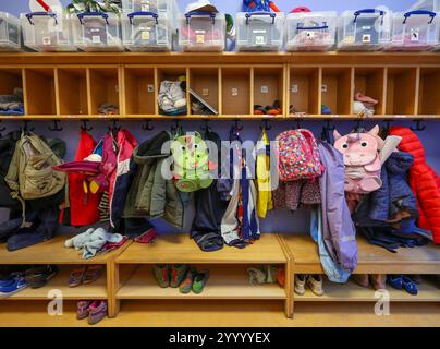 Germania - immagine simbolica KITA. Cappotti, giacche e zaini di unicorno di bambini appesi a un guardaroba in un asilo. Foto Stock
