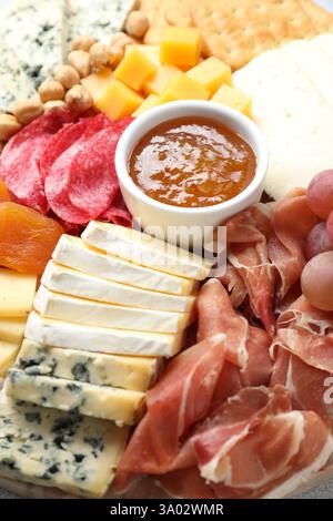 Diversi tipi di formaggio tagliato e altri spuntini, primo piano Foto Stock