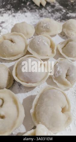 Gnocchi russi fatti a mano, produzione. I gnocchi crudi sono stati collocati su un tavolo da cucina in legno. Foto Stock