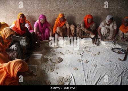 Donne devoti rendendo rotis a servita nel langar o la cucina della comunità a Harmandir Sahib o Tempio d'Oro Foto Stock
