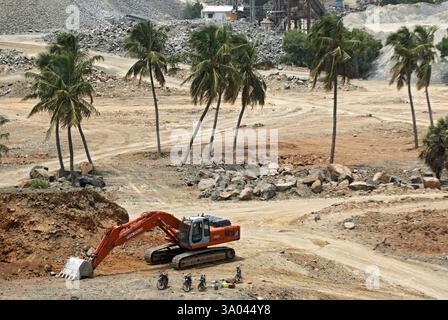 Escavatore idraulico vicino all'impianto di frantumazione della pietra sul sito della tangenziale, Madras Chennai, Tamil Nadu, India, 17 luglio 2008 Foto Stock