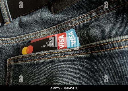 Venezia, Italia - 22 febbraio 2025: Carte di credito VISA e Mastercard all'interno di una tasca di jeans neri a Venezia, Italia. Foto Stock