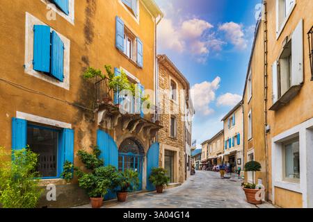 Affascinante strada nel pittoresco villaggio di Menerbes con edifici colorati e fiori vivaci. Villaggio di Menerbes (il più bel villaggio in Francia) nel Foto Stock