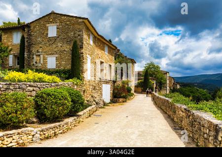 Affascinante strada nel pittoresco villaggio di Menerbes con edifici colorati e fiori vivaci. Villaggio di Menerbes (il più bel villaggio in Francia) nel Foto Stock