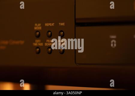 Lettore compact disc dallo stile retrò con dettagli ravvicinati di pulsanti di comando ed etichette, che mettono in risalto l'estetica tecnologica. Foto Stock