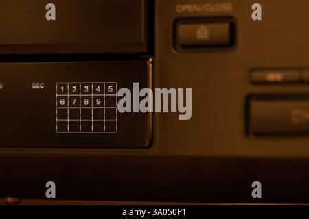 Lettore compact disc dallo stile retrò con dettagli ravvicinati di pulsanti di comando ed etichette, che mettono in risalto l'estetica tecnologica. Foto Stock