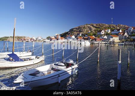 Piccolo porto con barche bianche e case colorate in una giornata di sole, costa dell'arcipelago, Hamburgsund, Bohuslaen, Svezia, Europa Foto Stock
