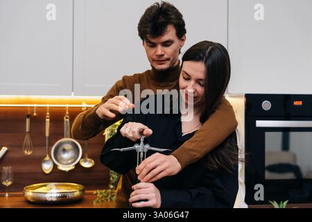 La coppia ama cucinare insieme in una cucina moderna mentre prepara la cena Foto Stock