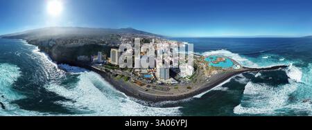 Vista aerea della spiaggia di Martiánez a Puerto de la Cruz, sulla costa settentrionale di Tenerife, nelle Isole Canarie, dominata dalla cima del Teid Foto Stock