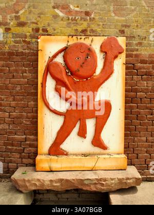 Rilievo in stile popolare di Hanuman a Varanasi, India, raffigurante la divinità che regge una montagna, simboleggiando devozione, forza e protezione nell'induismo. Foto Stock