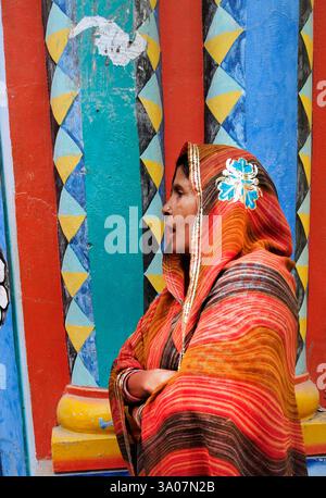 Una donna che si trova davanti al cancello del tempio Shri Bade Hanuman Ji ad Ayodhya, Uttar Pradesh, India. Foto Stock