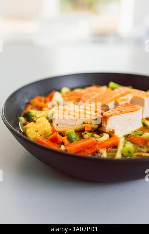 tagliatelle verdi al curry con tofu fritto in padella, ricette di cibi sani Foto Stock