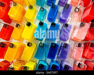 Multicolore trasparente di cover posteriori per smartphone. Custodia colorata fluorescente per cellulare con spazio vuoto per l'obiettivo della fotocamera, appesa ai ganci Foto Stock