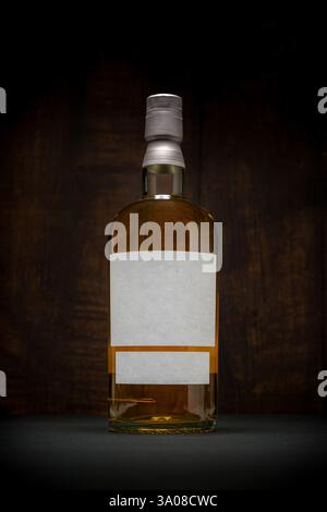 Bottiglia di whisky scotch single malt con etichetta vuota su sfondo scuro Foto Stock