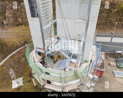 I lavoratori utilizzano una gru per fissare i materiali a un edificio alto, estensione della scala alla nuova torre della stazione ferroviaria di Calw sul nuovo binario dell'He Foto Stock