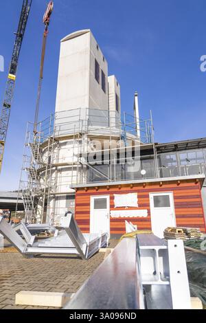 Edificio moderno con impalcature e gru sotto un cielo limpido in un cantiere, ampliamento delle scale fino alla nuova torre della stazione ferroviaria di Calw Foto Stock