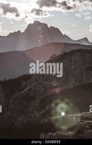 La splendida vista di un paesaggio montuoso inondato dalla luce soffusa del tramonto mette in risalto le formazioni rocciose e le profonde valli, catturando l'essenza della natura Foto Stock