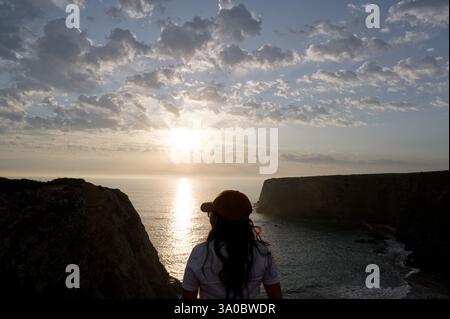 Il viaggiatore con le sue silhouette guarda il tramonto dorato su Tonel Beach Foto Stock