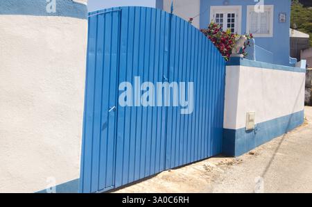 Porta d'ingresso in legno blu di una casa con pareti bianche tipiche del Portogallo Foto Stock