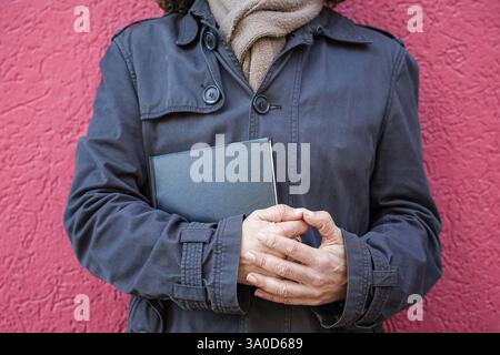 Primo piano di un uomo irriconoscibile che tiene un libro sulla giornata mondiale del libro Foto Stock