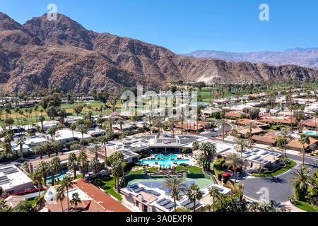 Vista aerea di una grande casa e di una comunità residenziale in un'area suburbana con un campo da golf e montagne in lontananza. Foto Stock