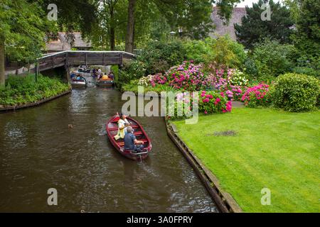 GIETHOORN, PAESI BASSI - AGOSTO 01 2017: Visitatori sconosciuti nel giro turistico in barca in un canale a Giethoorn. Le belle case e il giardinaggio Foto Stock