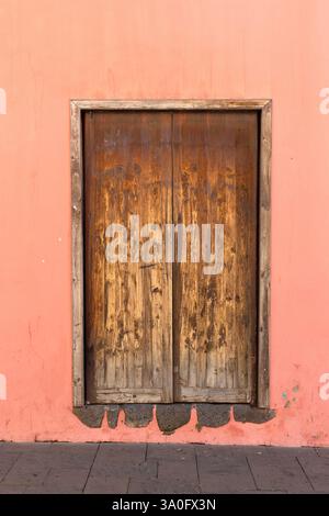 Vista esterna della vecchia porta in legno su pareti intonacate da utilizzare come sfondo Foto Stock
