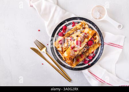 Pancake fatti in casa, piatti ripieni di formaggio spalmabile con frutti di bosco freschi Foto Stock