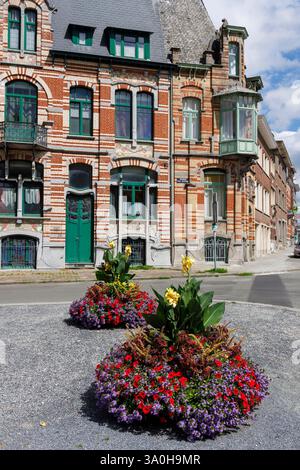 Fiori che crescono di fronte alla vecchia casa con balcone e torretta, Tournai, Belgio Foto Stock