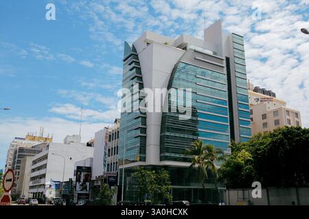 La vita cittadina è vivace a Colombo con edifici contemporanei che contrastano con un cielo azzurro e nuvole sparse. Foto Stock