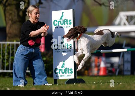 La paralimpica Ellie Simmonds, annunciata di recente nella line-up di presentazione del programma televisivo Crufts, fa il tifo per l'inglese Springer Spaniel Ozzy che salta su un ostacolo durante il lancio ufficiale del Crufts Dog Show 2025 al NEC di Birmingham. Data foto: Martedì 4 marzo 2025. Foto Stock