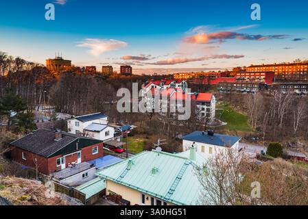 Uno splendido tramonto illumina un'area residenziale in Svezia, mettendo in risalto un mix di architettura tradizionale e moderna sotto un cielo vibrante pieno di Foto Stock