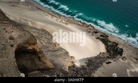 Esplora il suggestivo paesaggio di Socotra, dove le sabbie bianche si incontrano con le acque turchesi, incorniciate da scogliere rocciose e da una natura vivace. Foto Stock