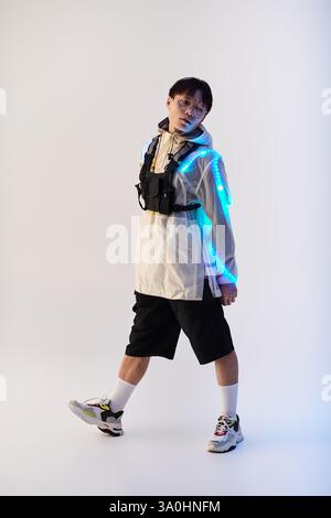 Un giovane asiatico sfoggia un outfit elegante con accessori brillanti all'interno. Foto Stock