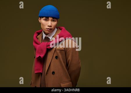 Il giovane e affascinante uomo sfoggia una moda moderna con accessori vivaci che trasudano carisma e stile. Foto Stock