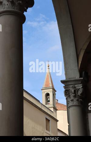Vista laterale del campanile della Basilica della Santissima Annunciazione, dall'angolo di un arco. Firenze Foto Stock