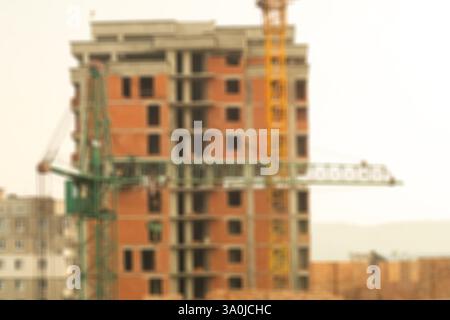 Foto sfocate del cantiere con gru e edificio a più piani incompiuto. L'effetto astratto crea uno stile visivo morbido. Perfetto per il backgroun Foto Stock