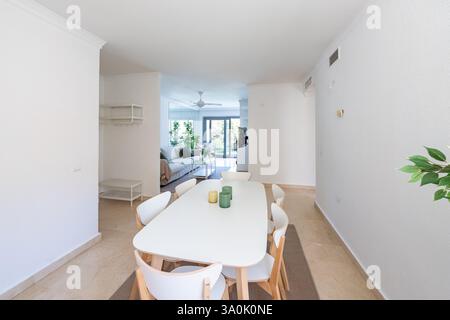 un'immagine di un tavolo da pranzo bianco e sedie nella casa vacanze mediterranea Foto Stock