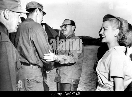 Mr. Alexander in Corea -- il sottosegretario dell'esercito Archibald Alexander (L-background) stringe la mano al comico Jack Benny che è in tour in Corea, mentre il tenente generale Edward M. Almond. (L-Foreground) parla con la star dello schermo Marjorie Reynolds. 4 luglio 1951. (Foto di J. Guzman, US Army Photo). Foto Stock