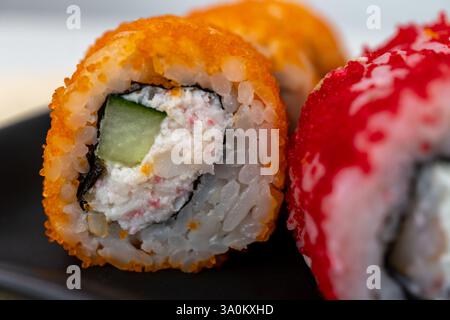 Primo piano di colorati sushi roll con tobiko e crema di formaggio Foto Stock