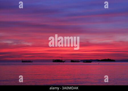 Vista all'alba della barca ormeggiata al largo dell'isola di Seraja Kecil, conosciuta anche come Seraya, al largo della costa di Labuan Bajo, Indonesia. Foto Stock