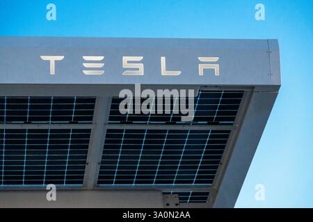 Baden-Württemberg, Germania - 4 marzo 2025: Un tetto solare Tesla con celle solari moderne e il logo distintivo Tesla. L'azienda si affida all'energia sostenibile e a tecnologie innovative per un futuro ecocompatibile, fotografato da un Supercharger, alimentato direttamente dal tetto. *** Ein Tesla Solardach mit modernen Solarzellen und dem markanten Tesla-Schriftzug. DAS Unternehmen setzt auf nachhaltige energie und innovative Technologien für eine umweltfreundliche Zukunft - aufgenommen bei einem Supercharger, welcher direkt vom Dach eingespeist wird. Foto Stock