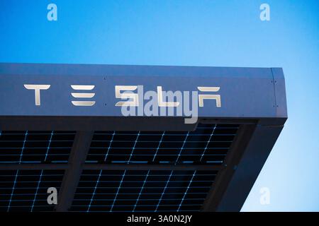 Baden-Württemberg, Germania - 4 marzo 2025: Un tetto solare Tesla con celle solari moderne e il logo distintivo Tesla. L'azienda si affida all'energia sostenibile e a tecnologie innovative per un futuro ecocompatibile, fotografato da un Supercharger, alimentato direttamente dal tetto. *** Ein Tesla Solardach mit modernen Solarzellen und dem markanten Tesla-Schriftzug. DAS Unternehmen setzt auf nachhaltige energie und innovative Technologien für eine umweltfreundliche Zukunft - aufgenommen bei einem Supercharger, welcher direkt vom Dach eingespeist wird. Foto Stock
