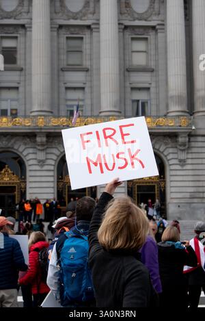 San Francisco, Stati Uniti. 4 marzo 2025. Una donna ha un cartello con scritto "FIRE MUSK", mentre i manifestanti si riuniscono di fronte al municipio di San Francisco per protestare contro gli ordini esecutivi del presidente Trump e le azioni del team DOGE di Elon Musk. Crediti: Shelly Rivoli/Alamy Live News Foto Stock