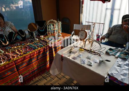 Banchina del mercato dei gioielli che espone collane, bracciali e orecchini fatti a mano con tovaglie colorate in una fiera all'aperto Powwow Foto Stock
