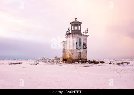 In inverno, il fiume San Lorenzo ghiacciato al livello del lago Saint-Pierre con il faro di fronte al Parc Écomareles de l'Anse-du-Port Foto Stock