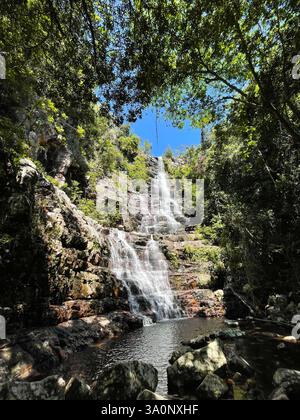 Cascata a più livelli che scorre su scogliere rocciose in una piscina naturale in una foresta tropicale Foto Stock