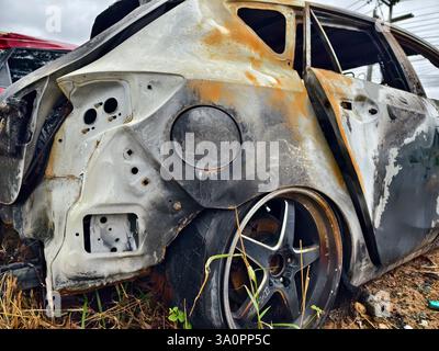 Resti carbonizzati di un veicolo lasciato indietro dopo un devastante incidente d'incendio. Foto Stock